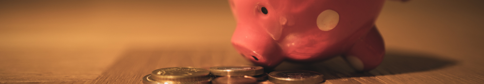 A pink piggy bank with coins