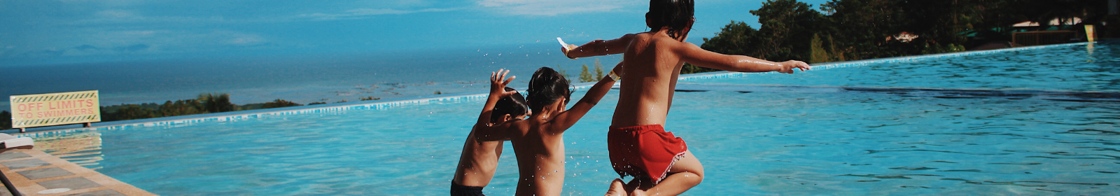 3 children jumping into a large pool